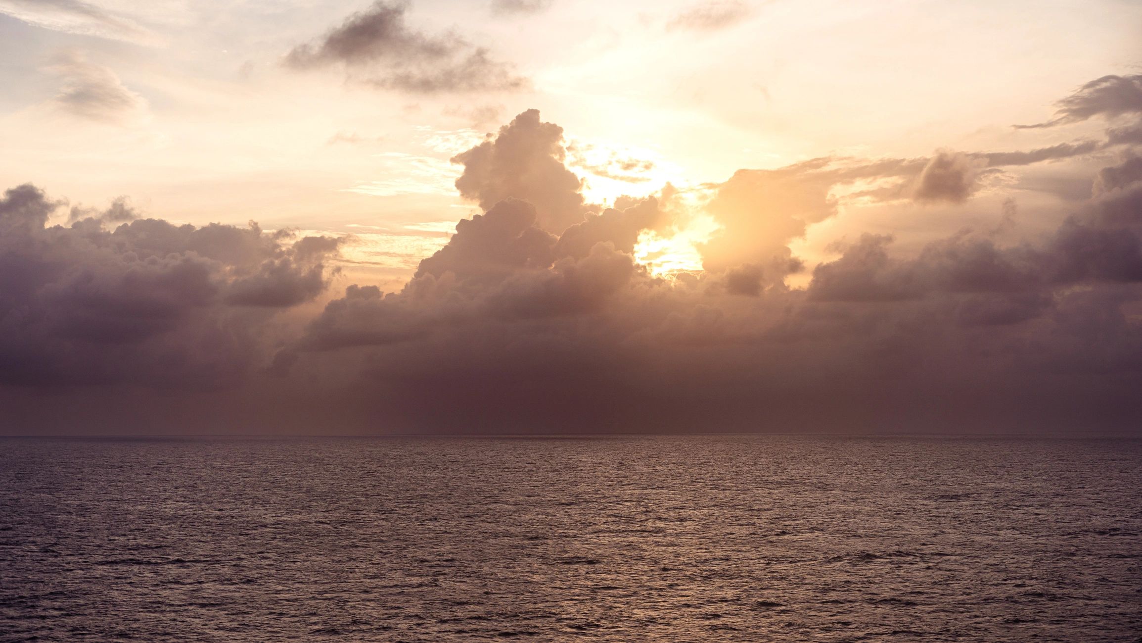 Sunset over the ocean from a ship’s deck