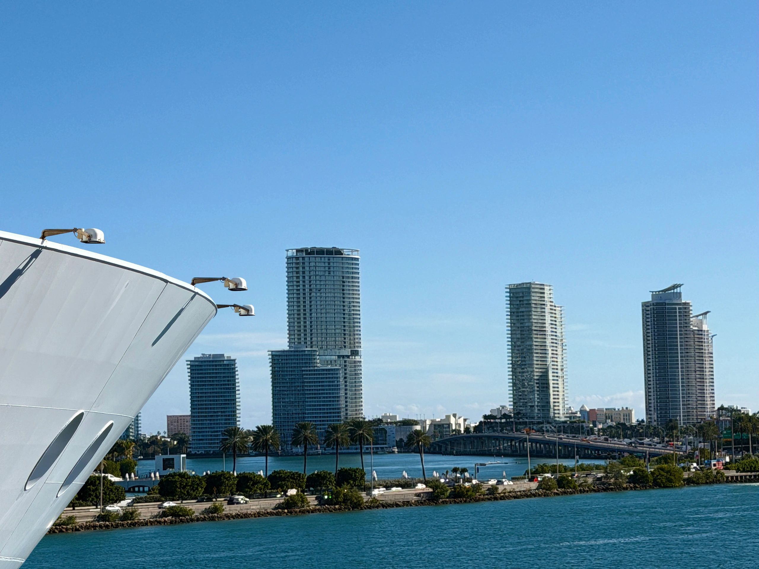 Cruise ship heading out to sea under a bright sky